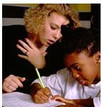 [photo of young woman teacher working with young student]